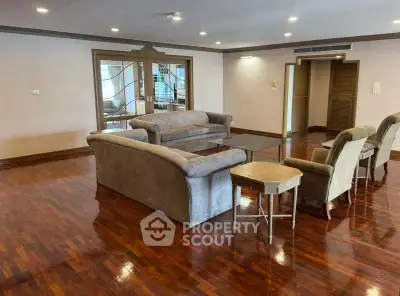 Spacious living room with elegant wooden flooring and comfortable seating in a luxurious apartment.