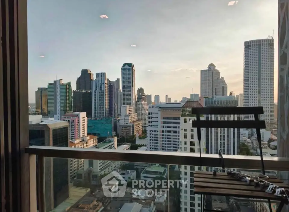 Stunning cityscape view from a high-rise balcony with modern skyscrapers at sunset.