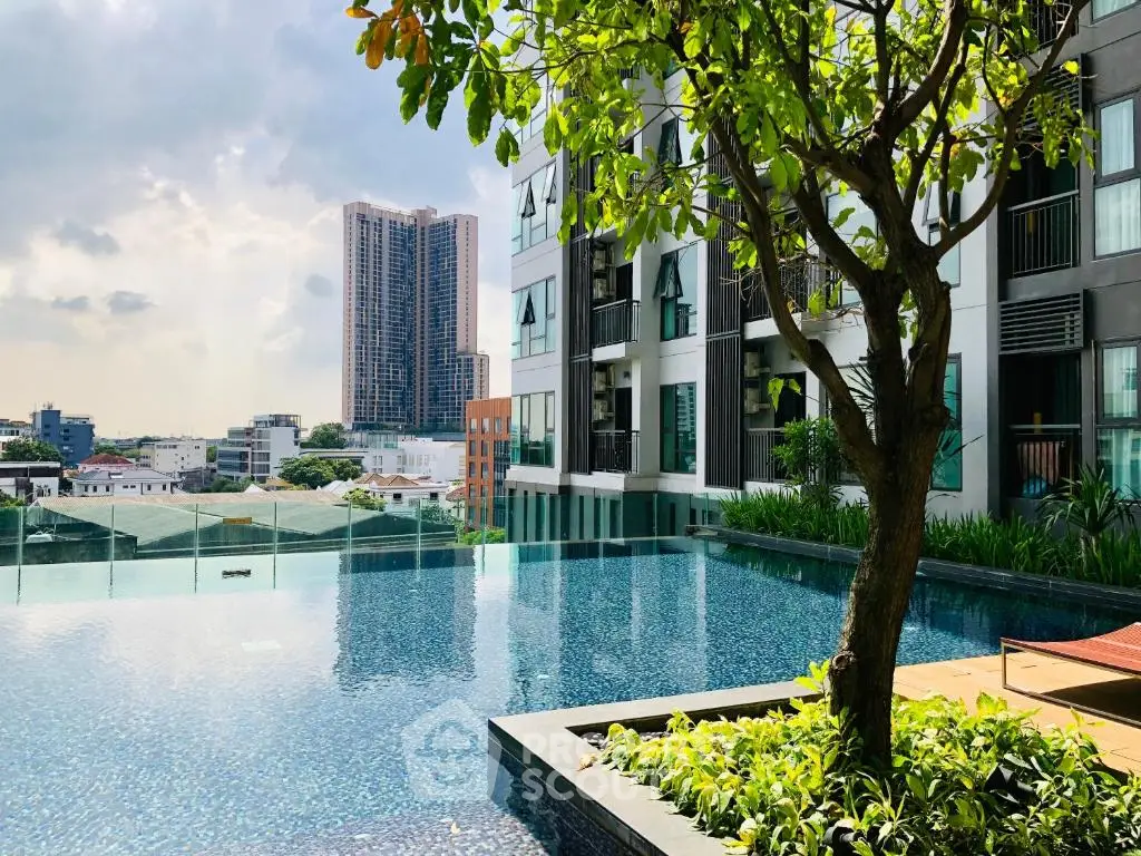 Luxurious apartment complex with stunning infinity pool and city skyline view.