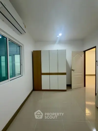 Spacious bedroom with modern wardrobe and sleek tile flooring