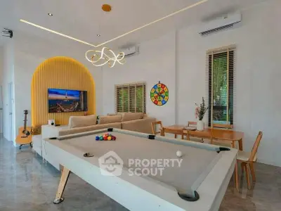Modern living room with pool table, stylish lighting, and cozy seating area.