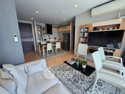 Modern open-layout living room with stylish furniture and integrated kitchen area, perfect for urban living.