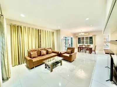 Spacious living room with elegant decor and dining area, featuring modern furniture and ample natural light.