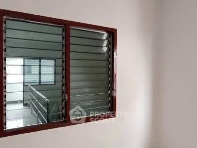 Minimalist interior with louvered window and neutral walls