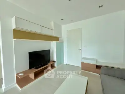 Modern living room with sleek furniture and mounted TV, showcasing minimalist design.