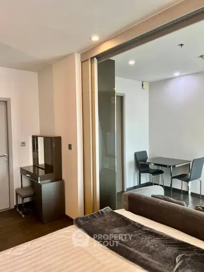 Modern studio apartment with sleek furniture and sliding glass partition, perfect for urban living.
