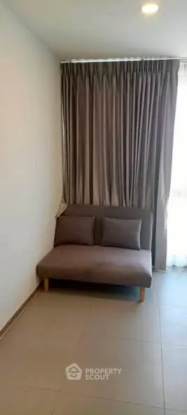 Cozy corner with a stylish sofa and elegant curtains in a modern living space.