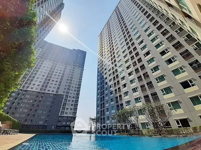 Stunning high-rise residential buildings with a sparkling pool and lush greenery, perfect for urban living.