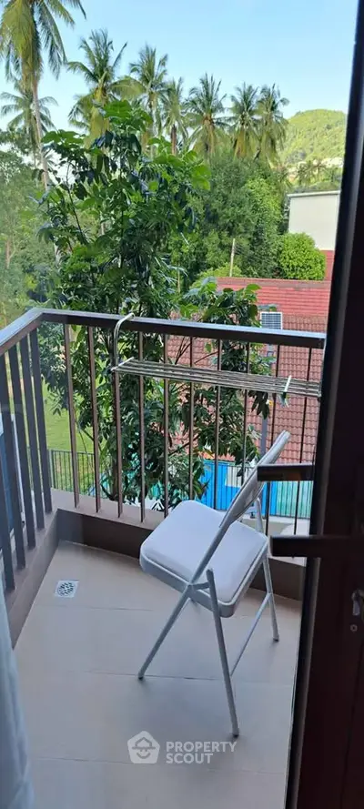 Charming balcony with lush greenery view, perfect for relaxation and enjoying nature.