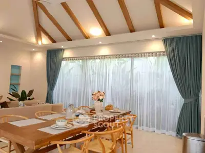 Elegant dining area with wooden beams and large windows in modern home
