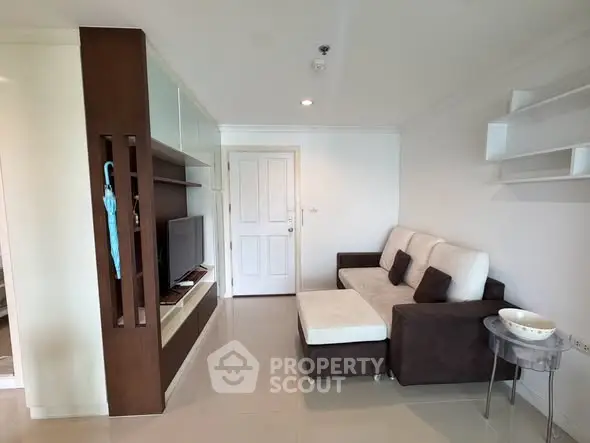 Modern living room with sleek furniture and stylish shelving in a cozy apartment.