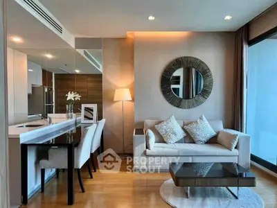 Modern living room with elegant decor, featuring a cozy sofa, stylish mirror, and dining area in a chic apartment.