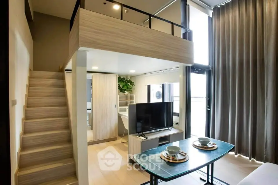Modern loft apartment with stylish mezzanine and open living area, featuring sleek furniture and abundant natural light.
