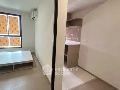 Modern apartment interior with sleek design and ample natural light, featuring a compact kitchen and spacious living area.