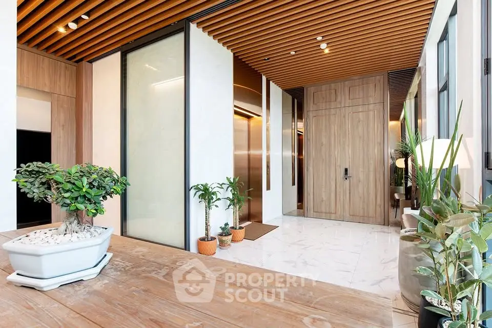 Luxurious modern entrance with wooden accents and elegant plant decor