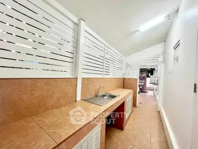 Spacious outdoor kitchen with tiled countertops and modern sink