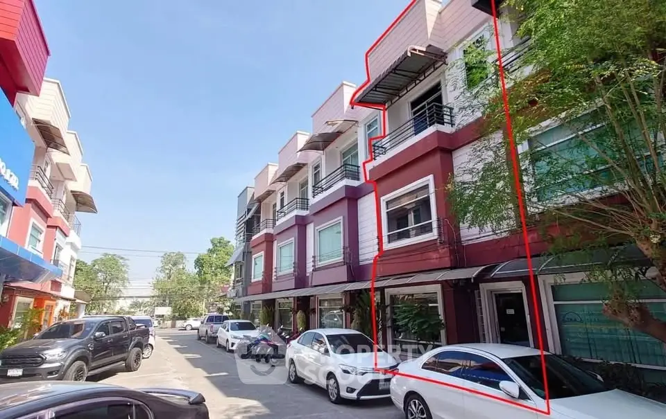 Modern multi-story commercial building with parking in vibrant urban area.