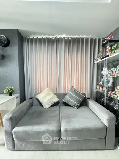 Modern living room with stylish gray sofa and decorative pillows, perfect for cozy relaxation.