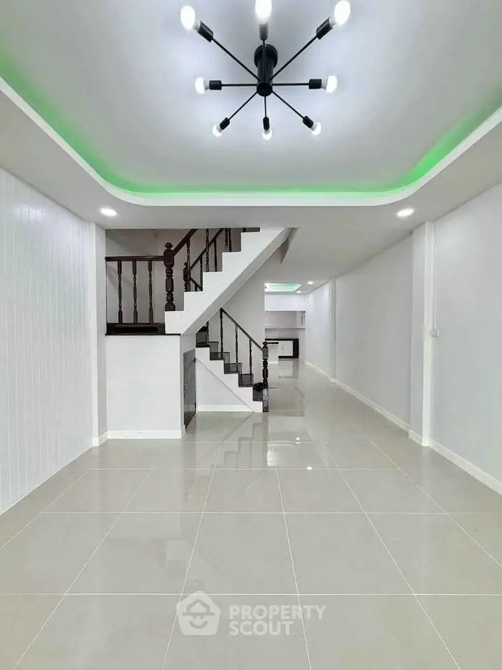 Modern interior with sleek staircase and stylish lighting in open layout living space.