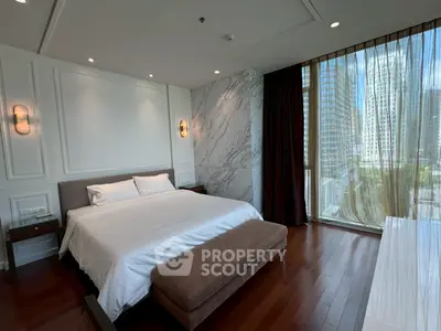 Luxurious bedroom with modern design and city view, featuring elegant marble wall and hardwood flooring.