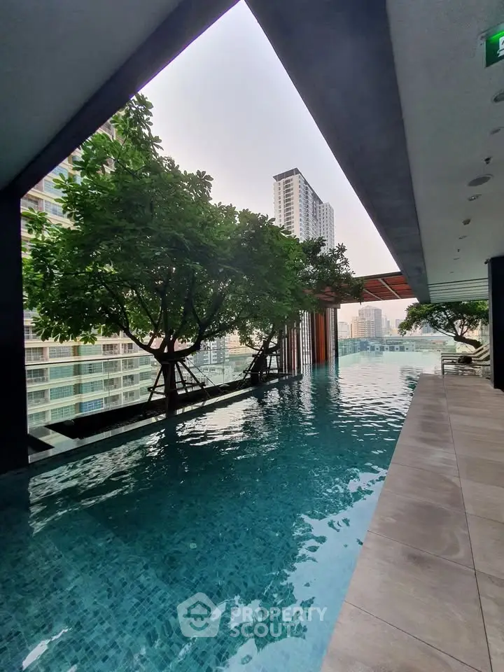 Luxurious rooftop pool with stunning city views and lush greenery in a modern high-rise building.
