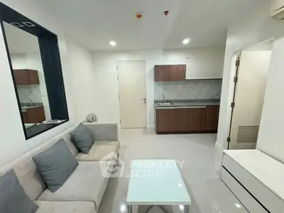 Modern living room with sleek kitchen in open layout, featuring stylish furniture and bright lighting.