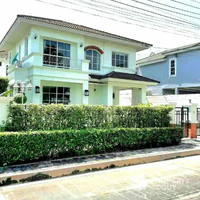 Charming two-story house with lush hedges and modern architecture in a serene neighborhood.