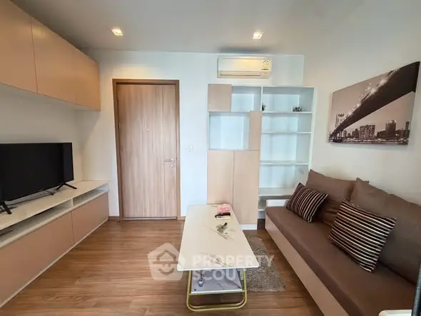 Modern living room with stylish furniture and wall-mounted TV in a cozy apartment.