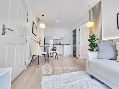 Modern living room with open kitchen, stylish decor, and cozy seating area.