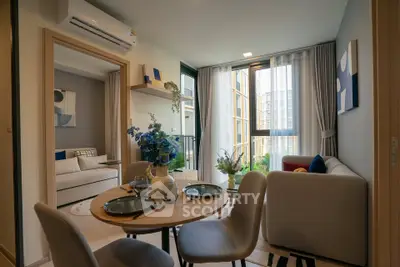 Modern living room with dining area and large windows offering natural light and a cozy atmosphere.