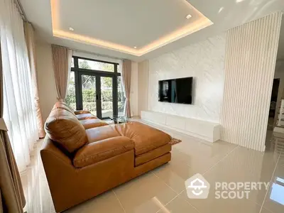 Luxurious living room with glossy tiled floors, plush leather sofa, and a sleek wall-mounted TV, bathed in natural light from large windows.