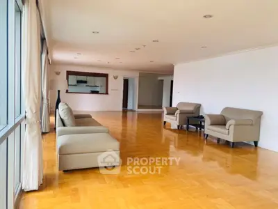 Spacious living room with elegant parquet flooring and modern furniture in a bright apartment.