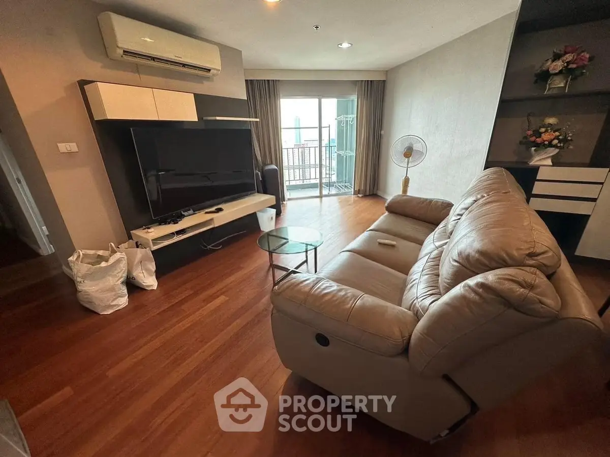 Spacious living room with modern furniture and balcony access in a stylish apartment.