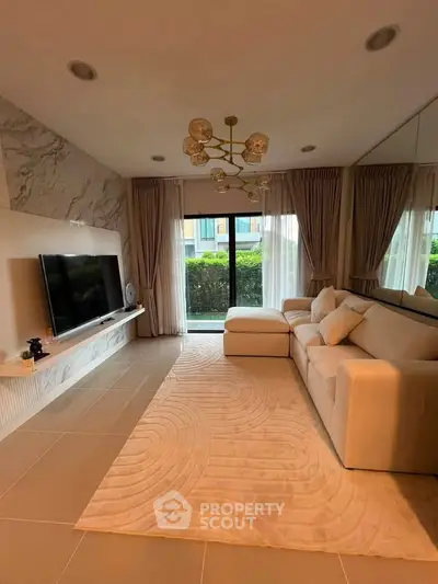Luxurious living room with elegant decor, large TV, and plush sofa, offering a cozy and inviting atmosphere.