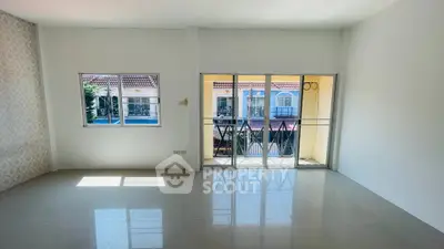 Spacious living room with large windows and balcony offering a charming view of the neighborhood.