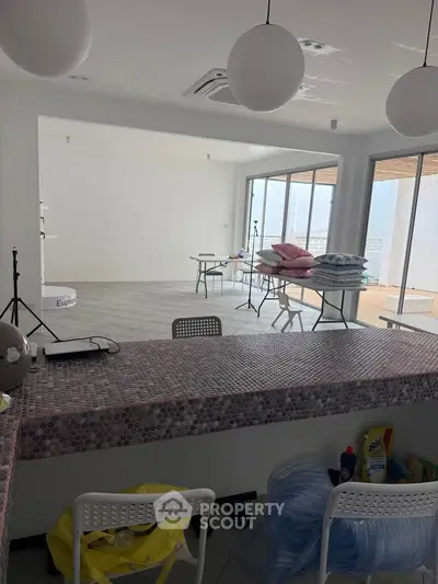 Spacious modern interior with large windows and stylish lighting, ideal for versatile use.