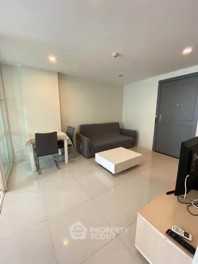 Modern living room with sleek furniture and tiled flooring in a contemporary apartment.