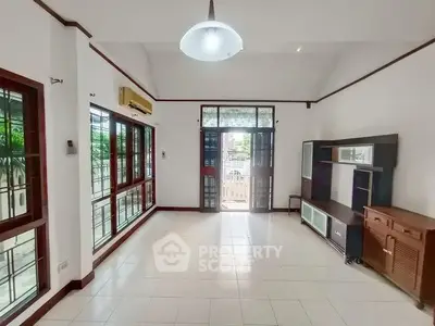 Spacious living room with large windows and modern furnishings in a bright, airy home.