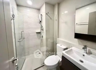 Modern bathroom with glass shower and sleek fixtures in a contemporary apartment.