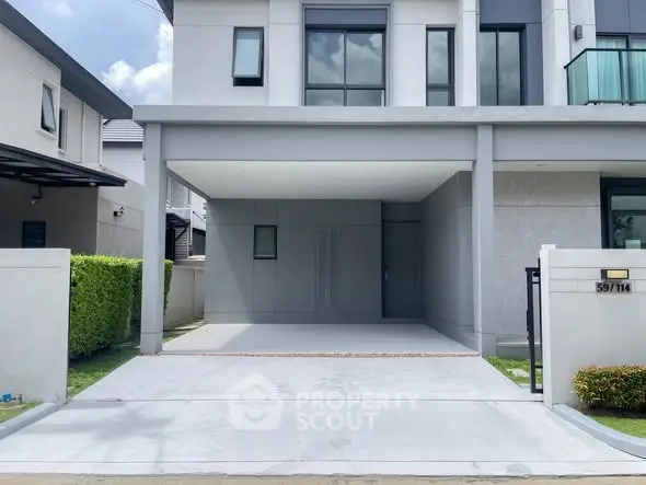 Modern two-story house with spacious driveway and sleek exterior design.