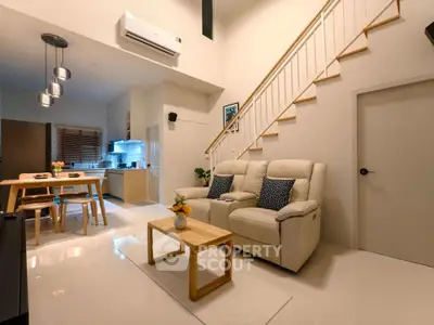 Modern living room with open kitchen and stylish staircase in cozy apartment