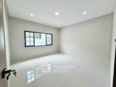 Spacious empty room with large window and glossy white tiles, perfect for customization.