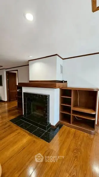 Spacious living room with elegant hardwood floors and a stylish fireplace.