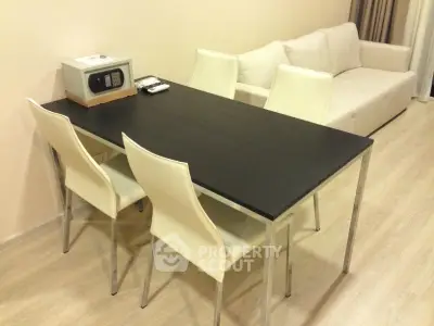 Modern living room with sleek dining table and comfortable sofa, perfect for stylish urban living.