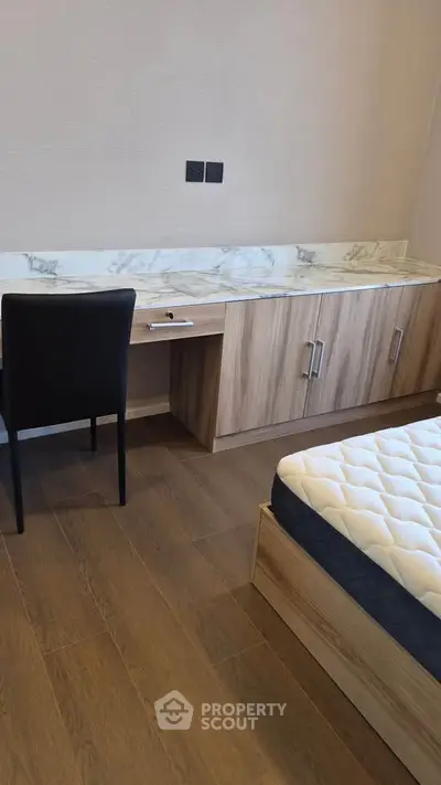 Modern bedroom with wooden flooring and stylish furniture
