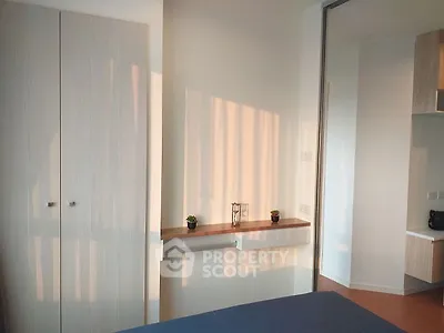 Modern bedroom with sleek wardrobe and natural light, perfect for urban living.