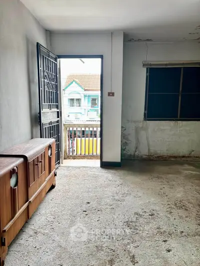 Spacious room with balcony access in need of renovation, featuring potential for customization.