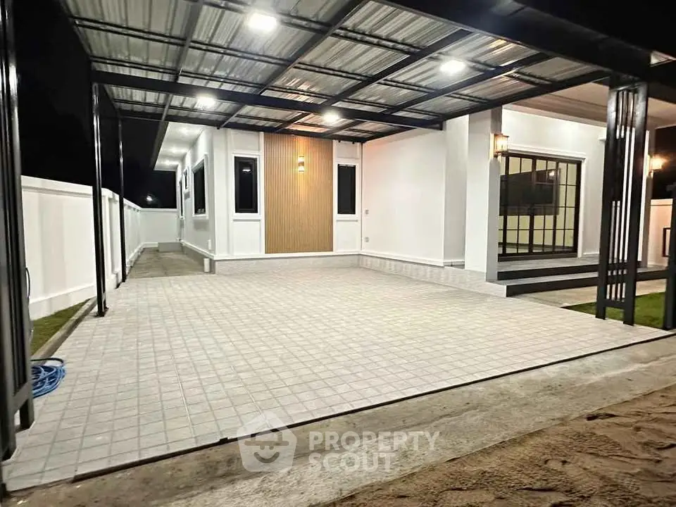 Modern home exterior with spacious tiled patio and stylish lighting