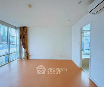 Spacious unfurnished room with large windows and city view, ideal for customization.