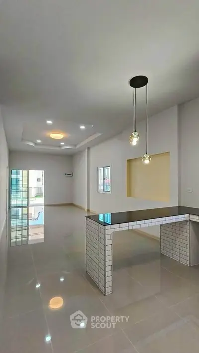 Spacious modern living room with sleek tile flooring and stylish lighting fixtures.